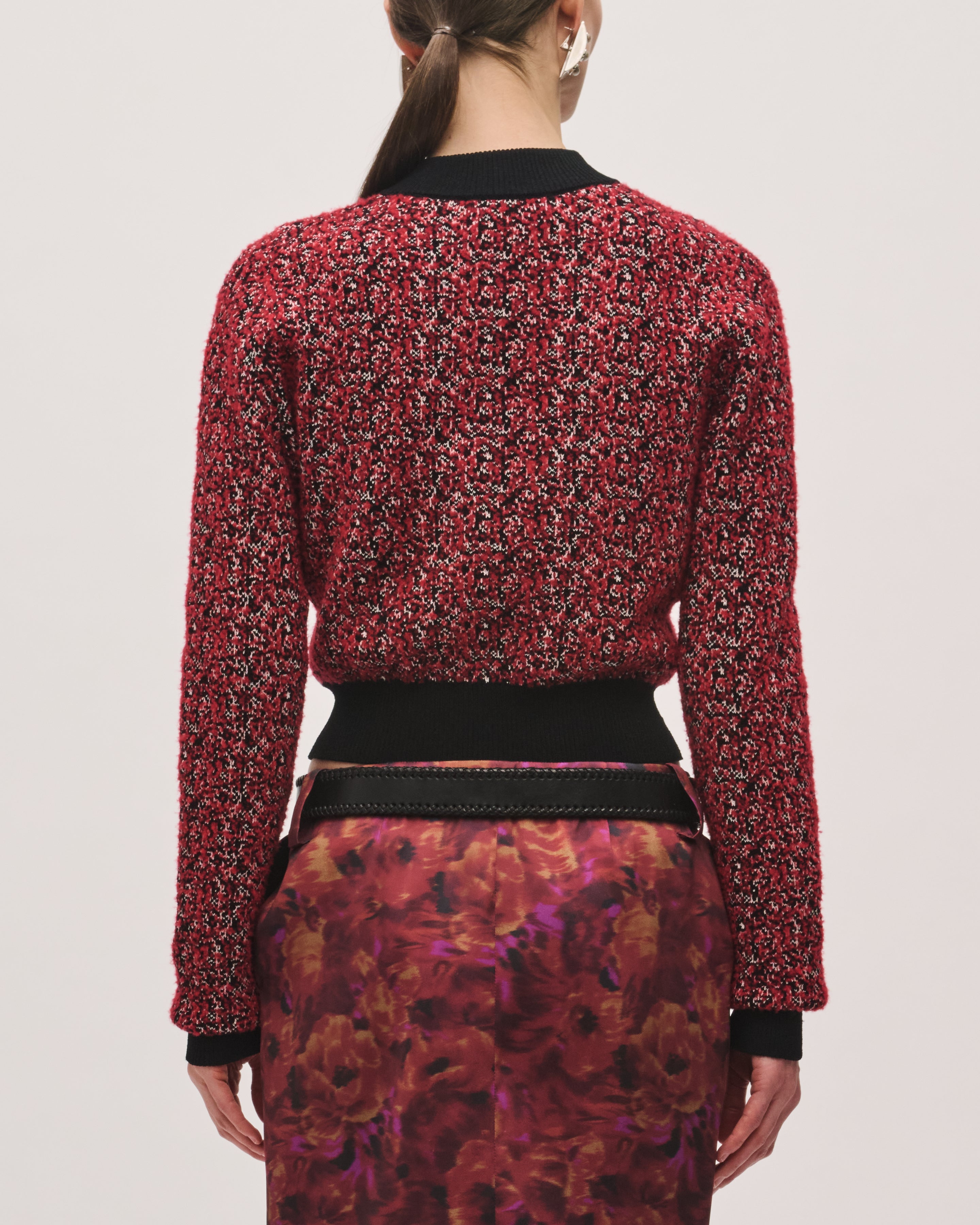 Back view of the Aubrey Cardigan in Red Static, showing the red-and-black patterned knit, long sleeves, and solid black ribbed hem.