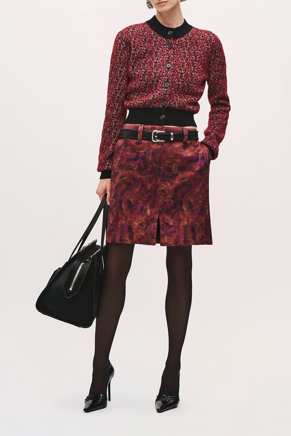 Front view of a model wearing the Aubrey Cardigan in Red Static, featuring a cropped silhouette, black ribbed crew neckline, black button-front closure, and long sleeves.