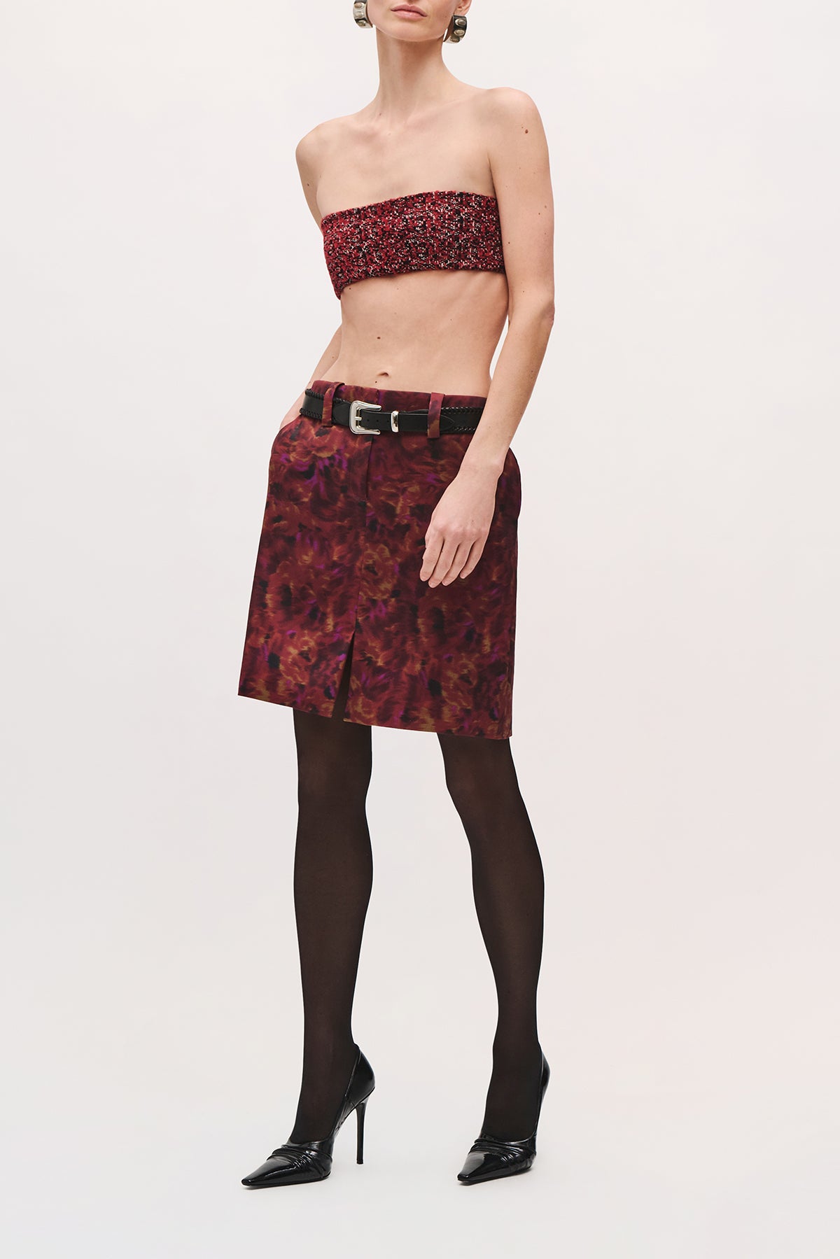Angled front view of a model wearing the Demi Bandeau in Red Static, a strapless cropped top with a red-and-black textured pattern.