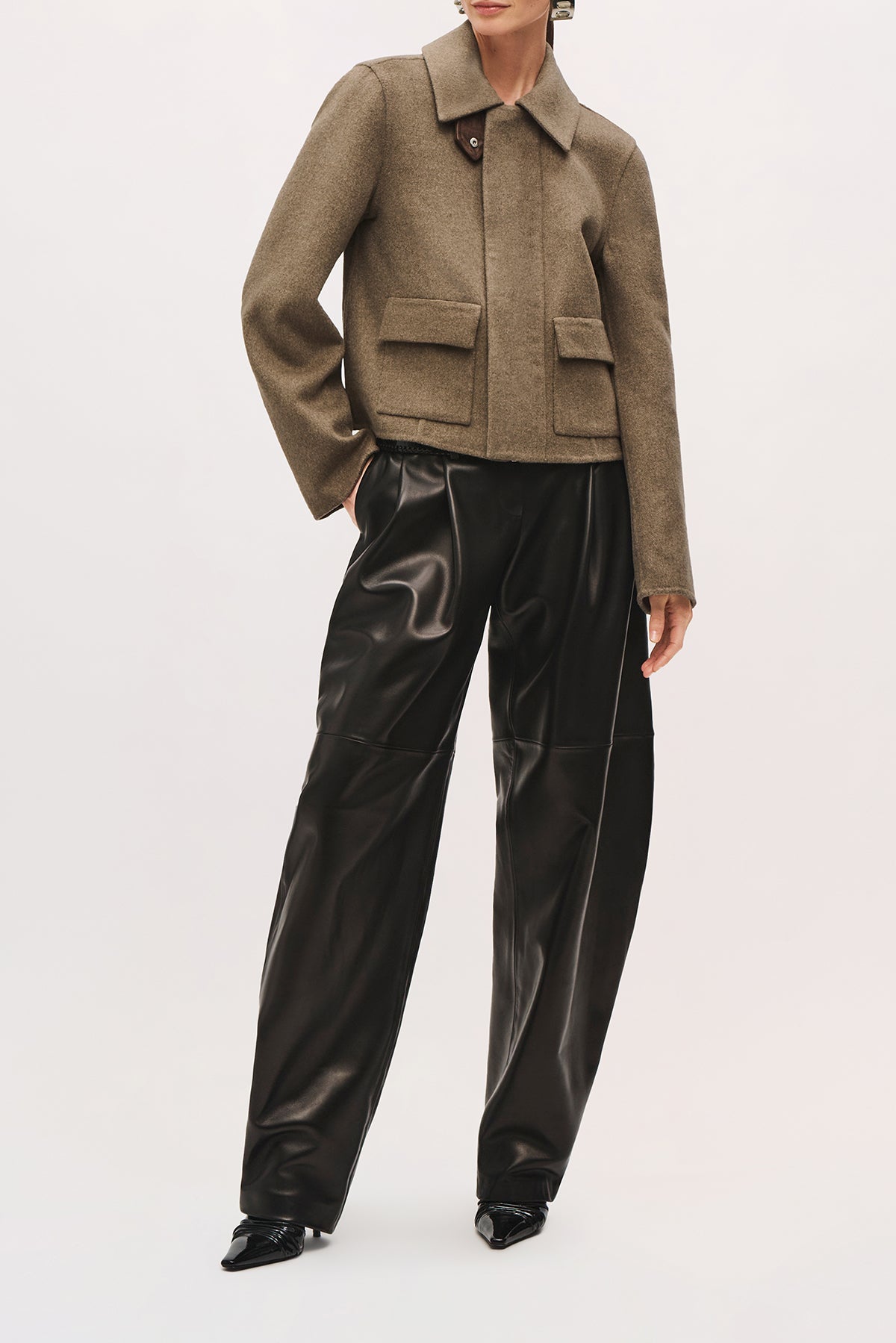 Front view of a model wearing the Remi Jacket in Truffle, with a pointed collar, two pockets, and a cropped fit.