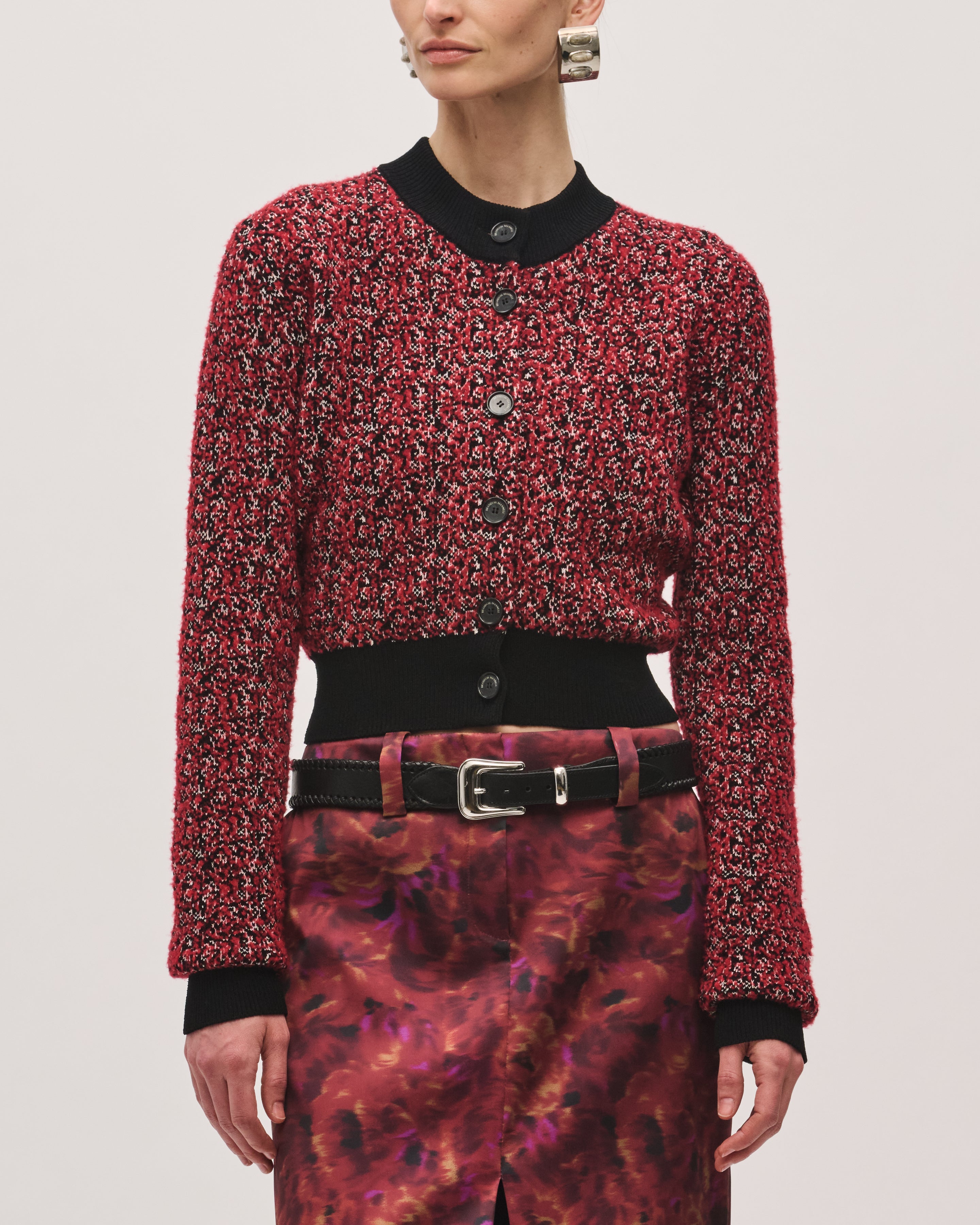 Straight-on product view of the Aubrey Cardigan in Red Static, a cropped knit cardigan with a red-and-black static pattern, black ribbed trim, and center-front buttons.