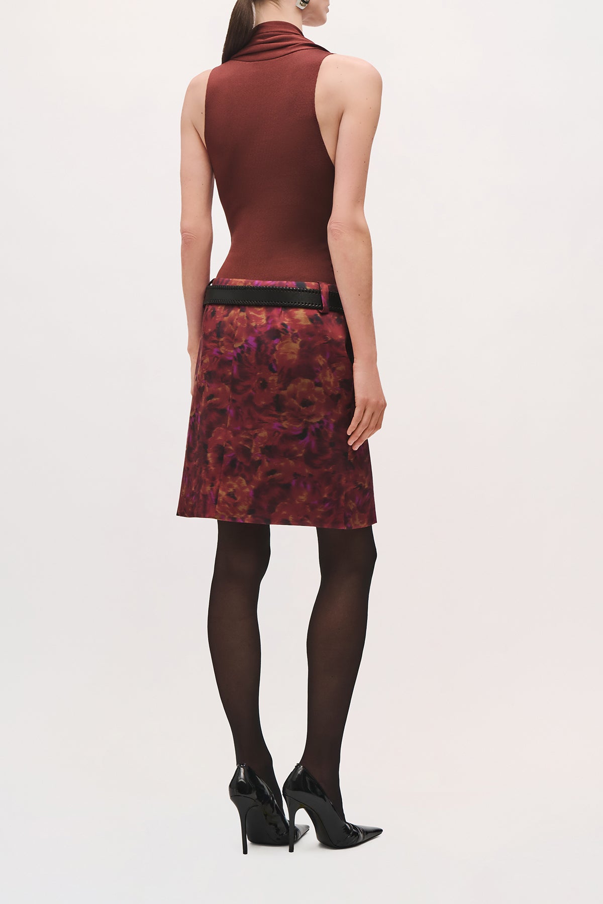 Back view of a model wearing the Capri Bodysuit in Terracotta, showing the cut-off sleeves. 