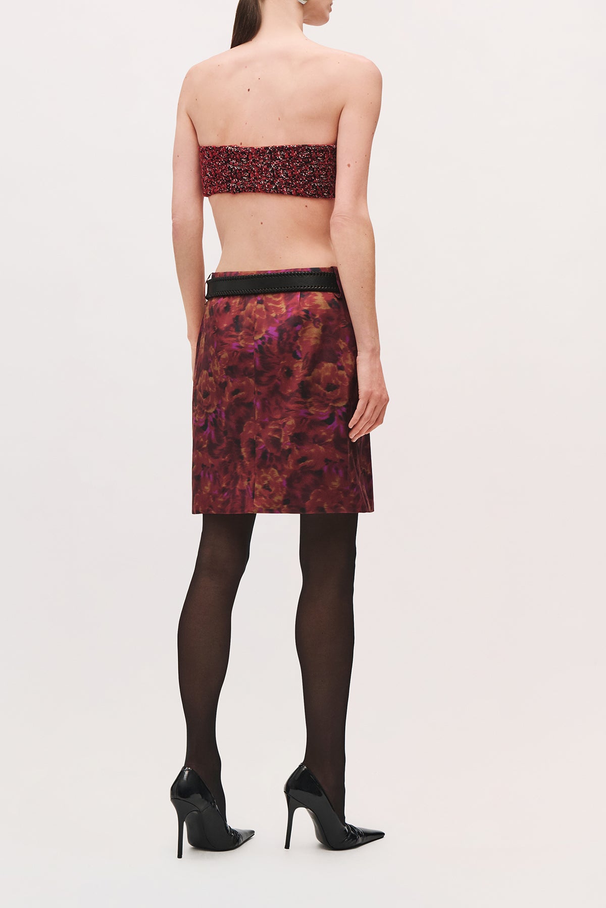 Back view of a model wearing the Demi Bandeau in Red Static, a strapless cropped top with a red-and-black pattern.