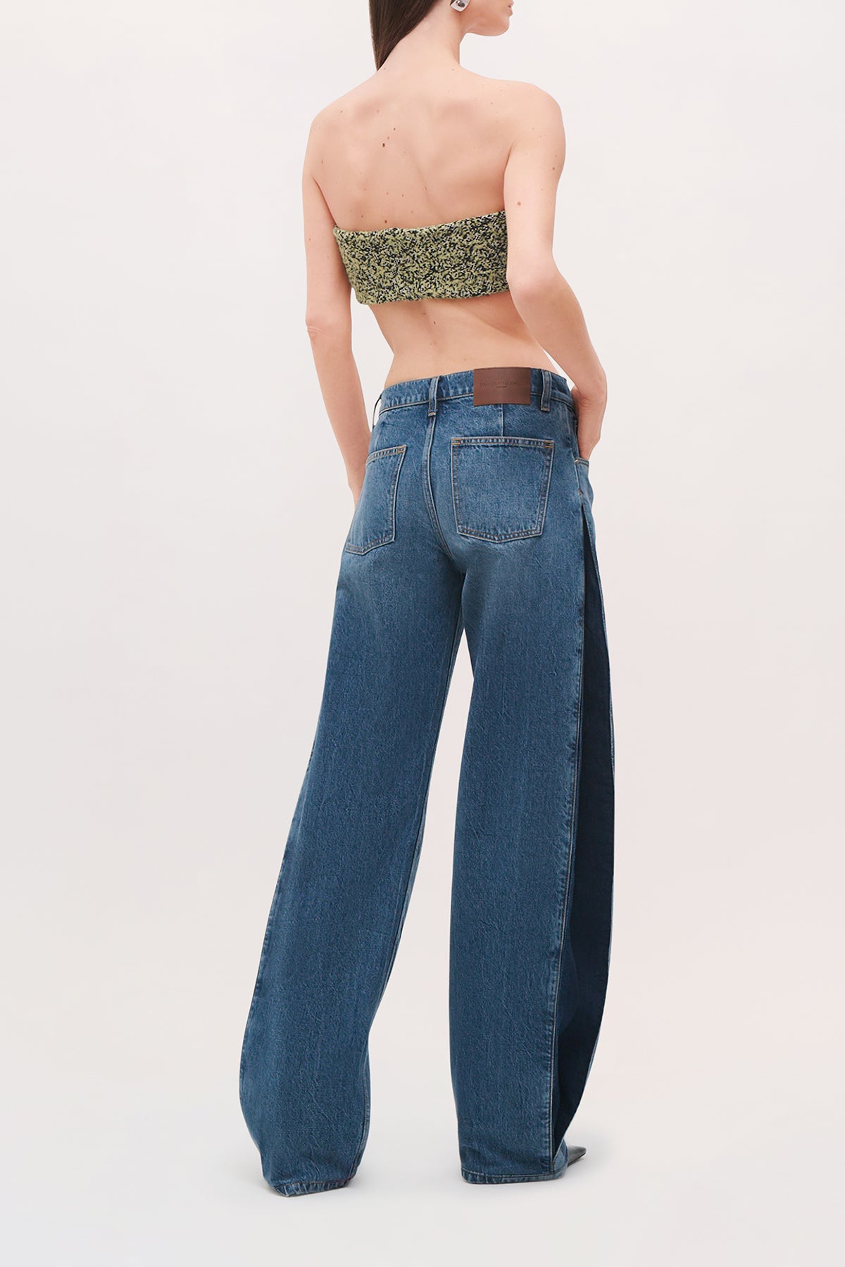Back view of a model wearing the Demi Bandeau in Green Static, a strapless cropped top with a green-and-black pattern.