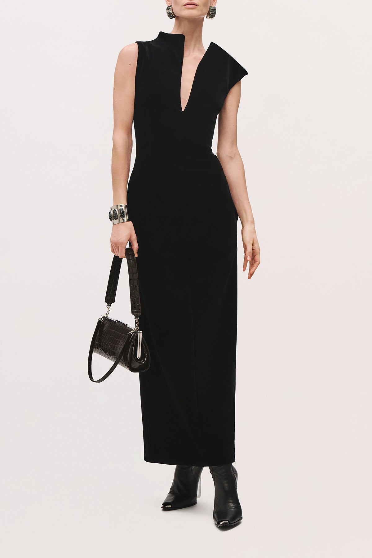 Front view of a model wearing the Farren Dress in Black, a sleeveless long dress with a deep V-neckline and straight silhouette.