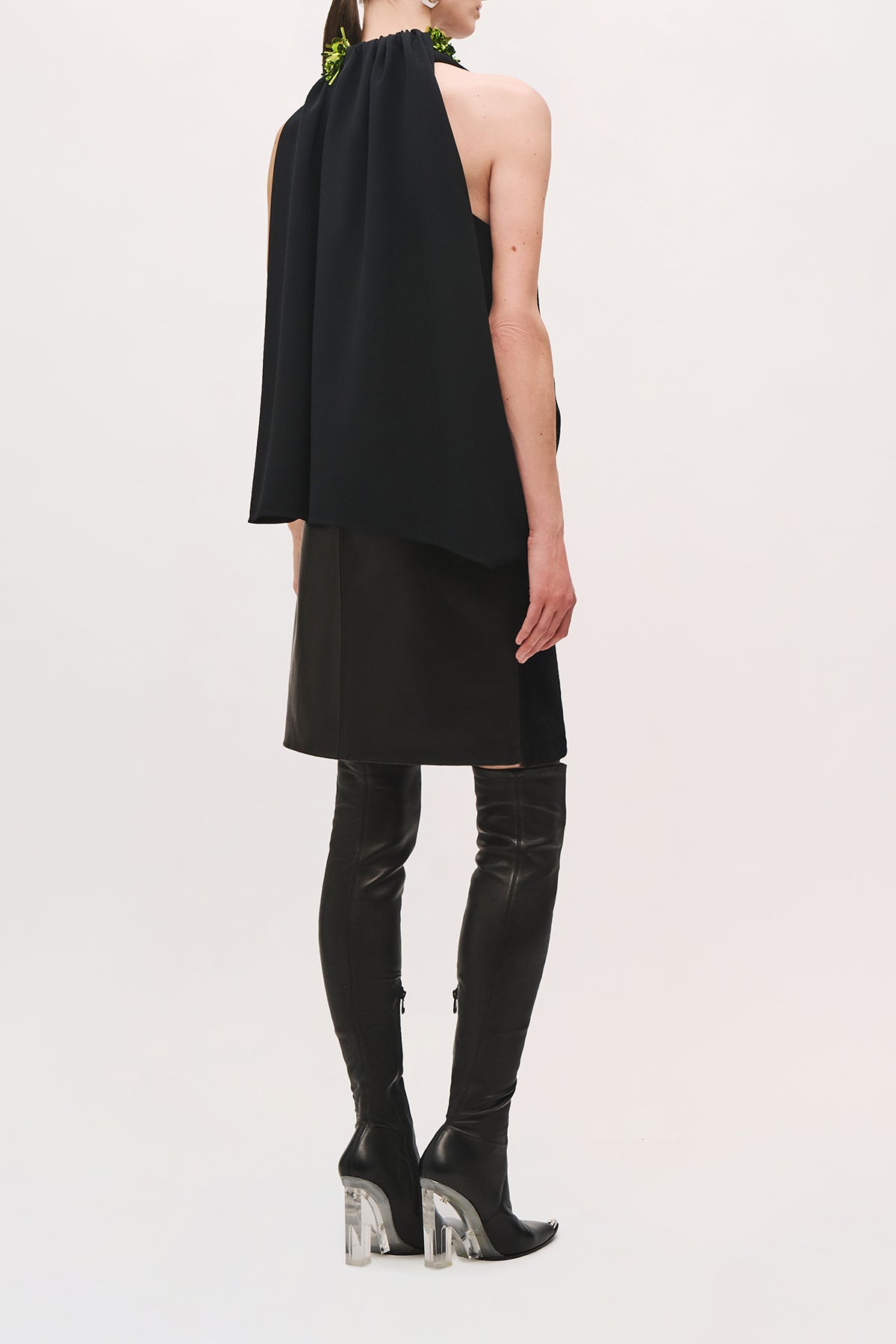 Back view of a model wearing the Haze Top in Black/Green;Glo, showing the gathered high neckline, black sequin shoulder details, sleeveless cut, and loose draped back.