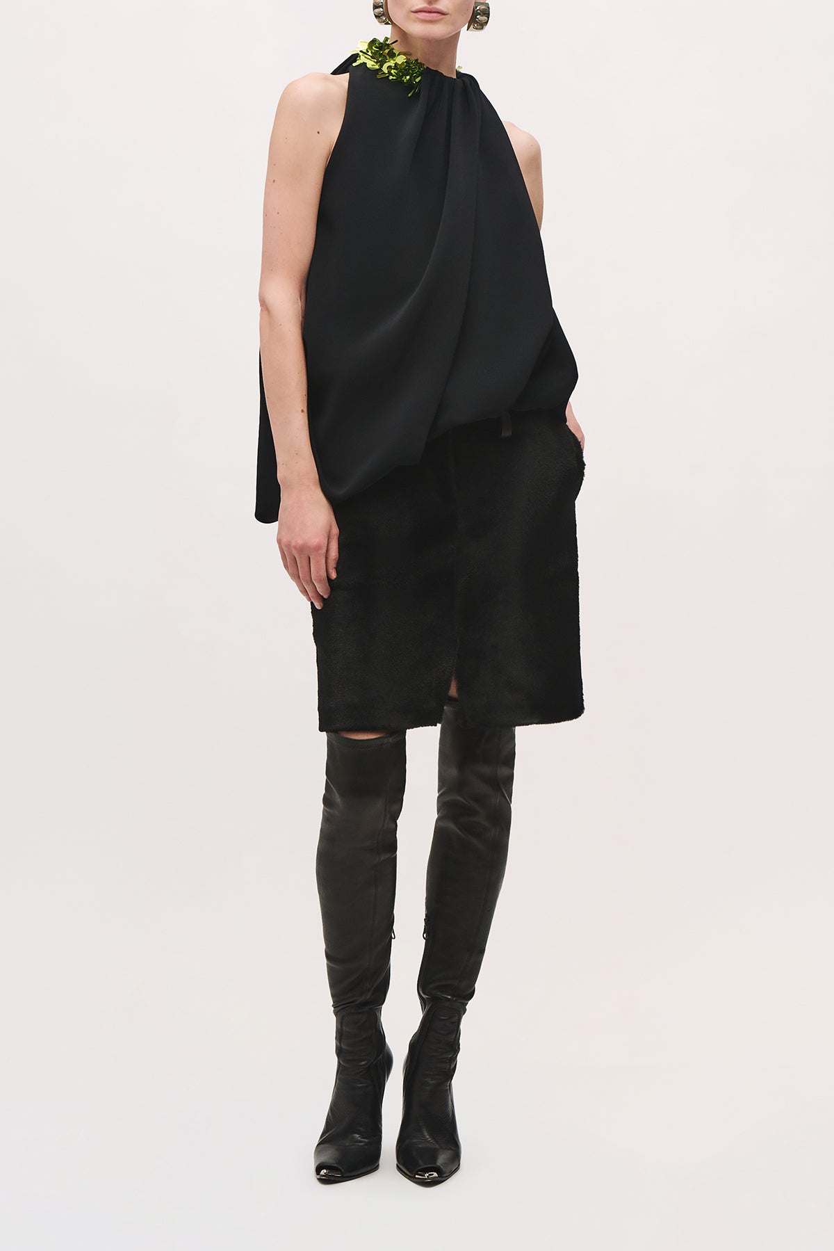 Front view of a model wearing the Haze Top in Black/Green;Glo, a sleeveless draped top with a gathered high neckline, black sequin embellishment at one shoulder, wrapping around the neckline. 