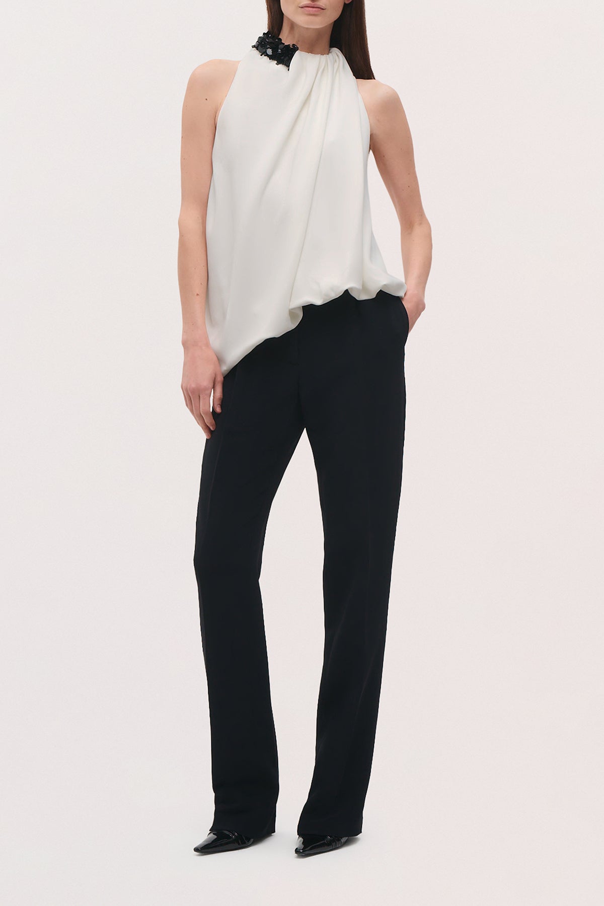 Front full body view of a model wearing the Irving Pant in black, a high-rise pant that features a straight, full-length leg and a clean tailored finish.