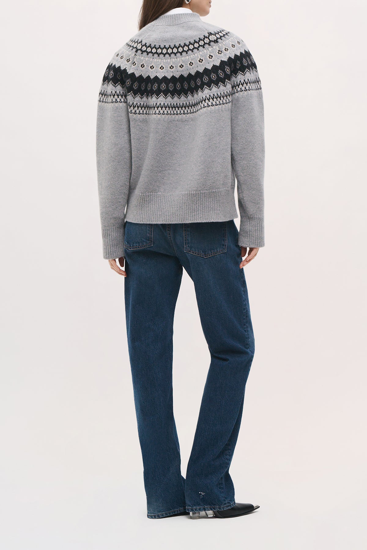 Back view of a model wearing the Joanna Sweater in Fair Isle, showing its relaxed shape, dropped shoulders, and straight hip-length hem. 