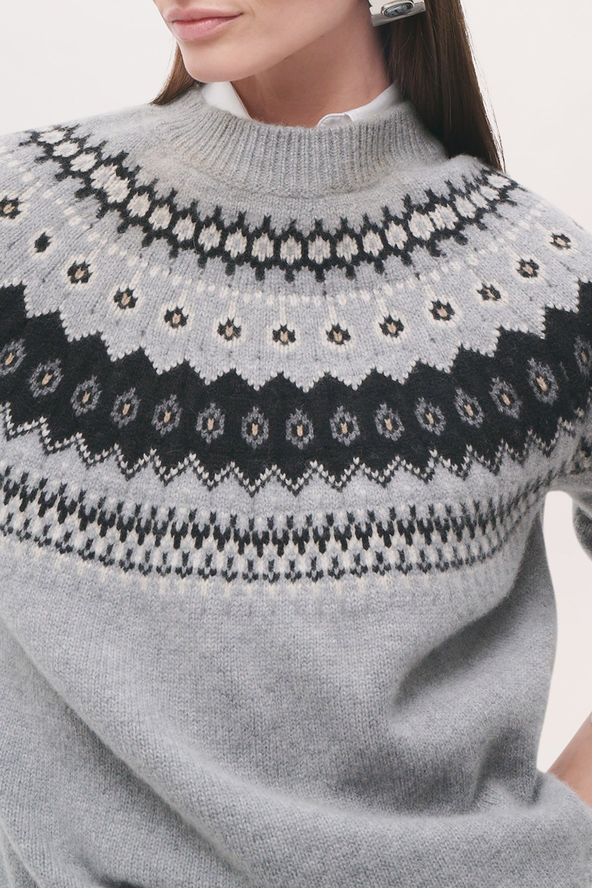 Detailed front view of a model wearing the Joanna Sweater in Fair Isle, highlighting its relaxed fit, ribbed crew neckline, and black-and-white patterned yoke.