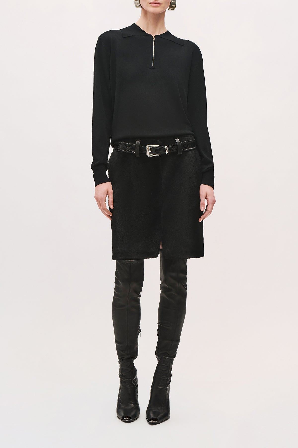 Front view of a model wearing the Keaton Sweater in black, wth a pointed collar and quarter zipper on the neckline.