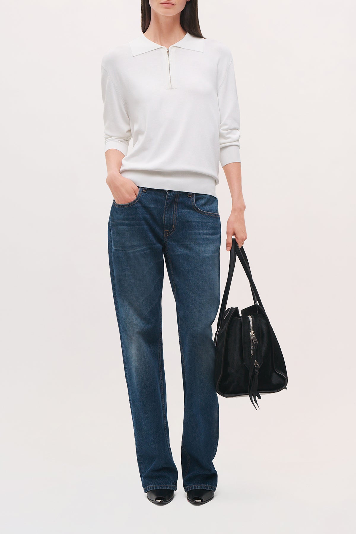 Front view of a model wearing the Keaton Sweater in white, wth a pointed collar and quarter zipper on the neckline. 