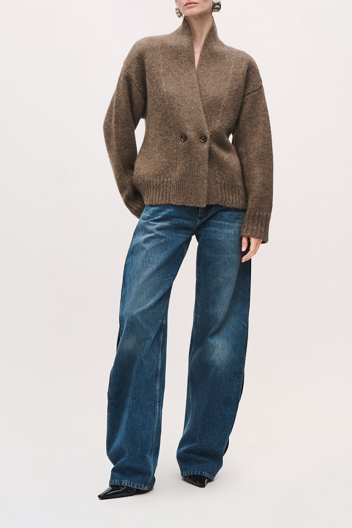 Front view of a model wearing the Lowen Cardigan in Truffle, with a double-breasted button closure and a loose fit below the hips.