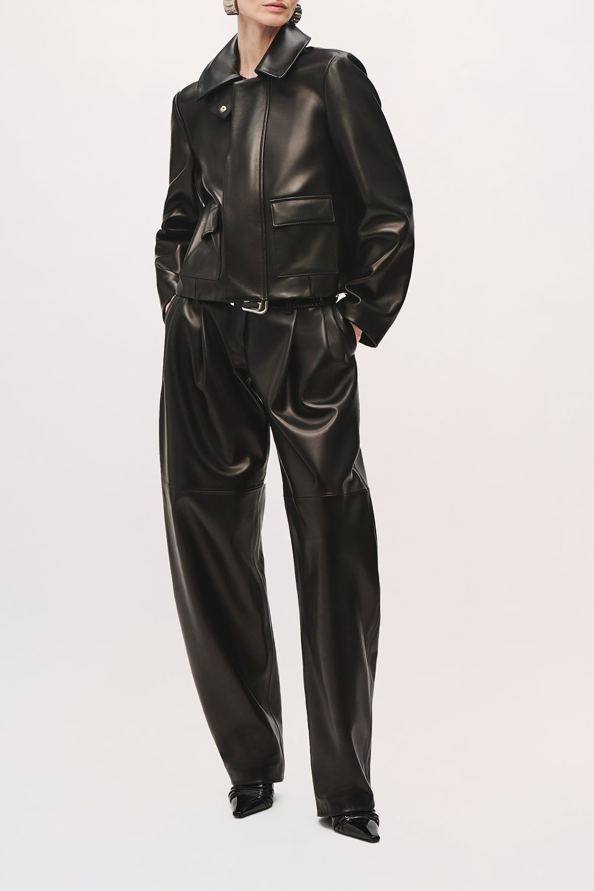 Front angled view of a model wearing the Remi Jacket in black with a pointed collar.