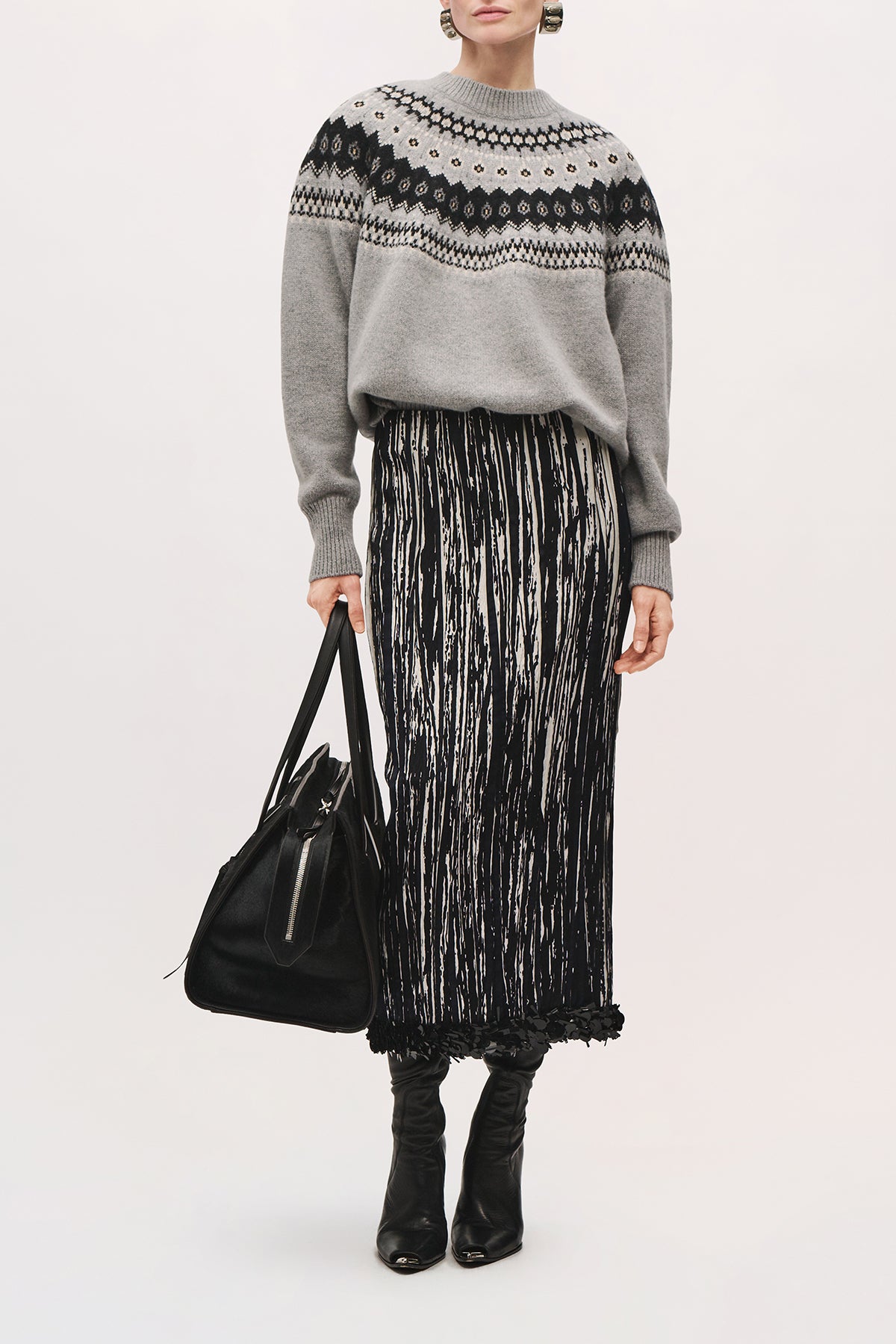 Front view of a model wearing the Sinclair Skirt in Black/White with leather purse a midi-length skirt with a straight silhouette and black sequin hem.